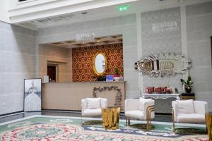 巴亚马雷Hotel Romanita的大堂设有沙龙,配有白色的椅子和镜子