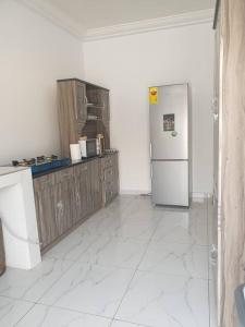 库马西Sigma Theta Homes - Old Tafo的厨房配有冰箱和木制橱柜。