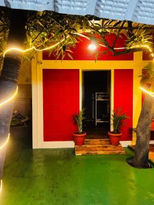 蓬蒂切里Hostel kuruku santhu colive的一座有红墙、盆栽植物和灯的房屋