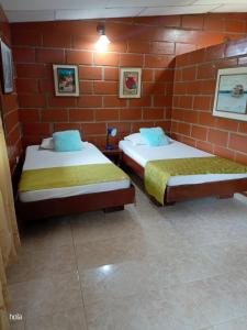 瓜塔佩Cabañas La Honda的砖墙客房的两张床