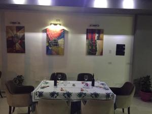BulqizëHotel Zogu的用餐室配有桌椅和绘画作品