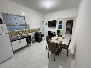 卡拉瓜塔图巴Casa nova e móveis novos的厨房以及带桌子和冰箱的用餐室