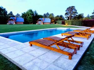 本塔纳山村Solar de las Sierras的游泳池旁的几把躺椅