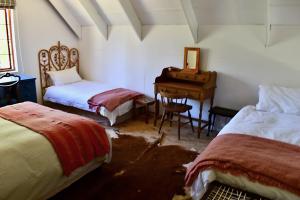 安德伯格Bamboo Mountain Farm的一间卧室配有两张床、一张桌子和一架钢琴