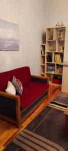 科莫蒂尼Like your home的客厅配有红色沙发和书架