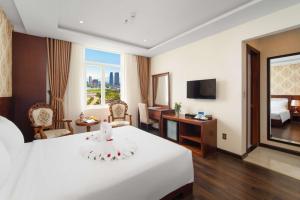 岘港NATURE Hotel By K D H的酒店客房设有一张白色大床和一张书桌