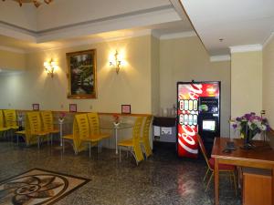 皇后区发达盛大酒店的餐厅设有苏打水机、桌子和黄色椅子