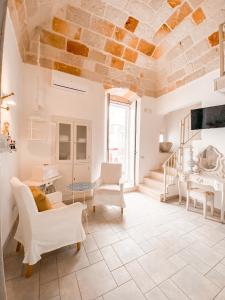 滨海波利尼亚诺卡伦楼住宿加早餐旅馆的客厅配有白色家具和石质天花板