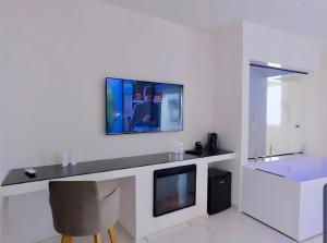 佩斯基奇Suite Èlite Rooms的一间客厅,在白色的墙上配有电视