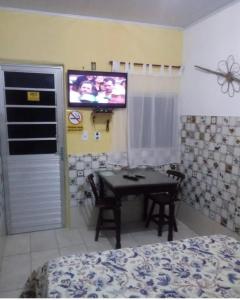 Fazenda NovaPousada em Fazenda Nova Dona Rosy的卧室配有桌子和墙上的电视。