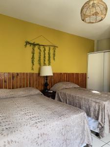 圣萨尔瓦多Hotel Andoria的黄色墙壁客房的两张床