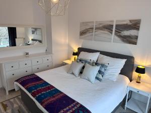 韦瑟灵Village Vista Penthouse的卧室配有一张带白色床单和枕头的大床。