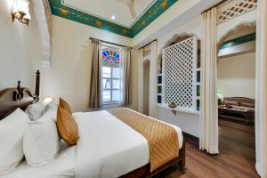 潘切库拉WelcomHeritage Ramgarh的卧室配有白色的床和窗户。