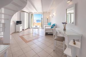 菲罗斯特法尼圣托里尼遐想酒店的白色的客厅配有桌椅
