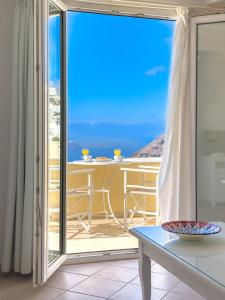 菲罗斯特法尼圣托里尼遐想酒店的阳台配有桌子,享有海景。