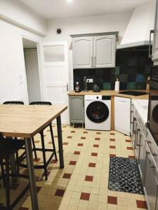 沙尔姆Appartement spacieux的厨房配有桌子和洗衣机。