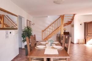 弗林布尔克Vila Lipno的一间带木桌和木楼梯的用餐室