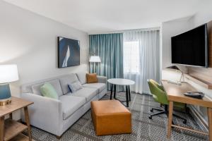 丹佛丹佛樱桃溪驻桥套房酒店的客厅配有沙发和桌子