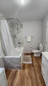 温尼伯St B. Living的白色的浴室设有浴缸和卫生间。
