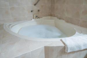古斯曼城HOTEL ZAPOTLAN的浴室内带毛巾的白色浴缸