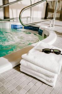温哥华蓝色地平线酒店的浴缸旁的毛巾上放着一双太阳镜