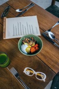 埃斯孔迪多港Terrestre, a Member of Design Hotels的一张木桌,上面放着一碗食物和一盘水果
