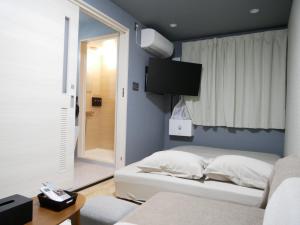 奄美HOOD - Vacation STAY 46460v的卧室配有一张床,墙上配有电视。