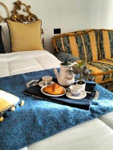 比萨PALACE COMFORT INN的床上的早餐盘,上面有茶具