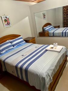 AguaytíaHOSTAL LOS NOGALES的一间卧室配有两张蓝色和白色条纹的床