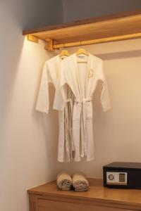 圣爱奥尼斯米科诺斯Birdhouse Private Luxury Suite的挂在微波炉旁边的架子上的白色长袍