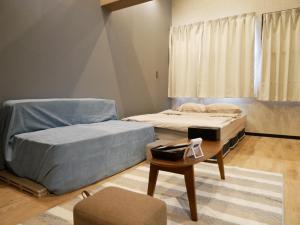 奄美HOOD - Vacation STAY 46324v的配有一张咖啡桌和一张桌子的客房内的两张床