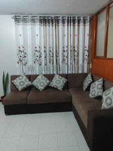 塔克纳Departamento 4 camas 3 hab的客厅配有带枕头的棕色沙发