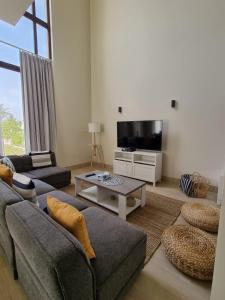 塞拉莱Hawana Salalah Villa的带沙发和电视的客厅