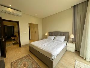 塞拉莱Hawana Salalah Villa的一间卧室配有一张带白色床单的大床