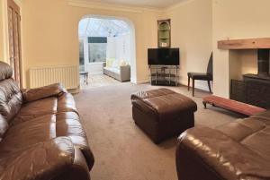 DeanFantastic central home的客厅配有真皮沙发和电视