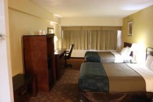 桑兹顿Dominion Inn and Suites的酒店客房配有两张床和一张书桌