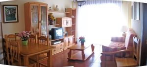 圣维森特-德拉巴尔克拉EN PLAYA SAN VICENTE DE LA BARQUERA的客厅配有桌子和电视