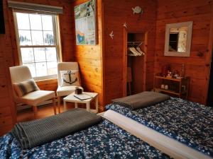 Saint Louis de KentL'Ancrage B&B and Cottages的卧室配有床、椅子和窗户。