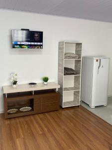 约恩维利RCM Vilas - Studio 103 Deluxe的一间设有白色冰箱和架子的客房