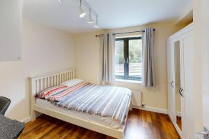 诺丁汉Lovely two bed flat with free parking (4 117)的一间卧室设有一张床和一个窗口