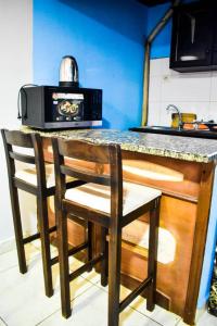 班基6 Appartements/ 6 studios privé à Bangui RESIDENCE RENESSIOT的厨房柜台配有两把椅子和微波炉
