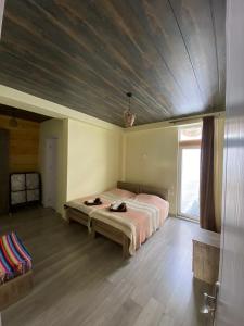 古多里Mountain Dream House的一间卧室设有一张带木制天花板的大床
