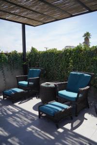 拉巴斯Villa Esterito的庭院里设有三把椅子和一张桌子