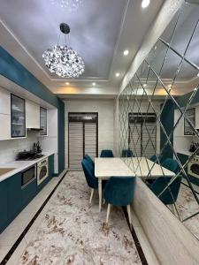 塔什干Tashkent city Boulevard 3 roomed apartment的一间带桌子和蓝色椅子的用餐室