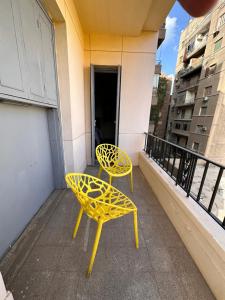 开罗Economy room in Downtown的阳台一对黄色椅子