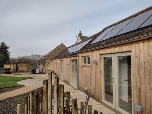 德斯利The Cow Byre - Cotswold retreat with hot tub的屋顶上设有太阳能电池板的房子