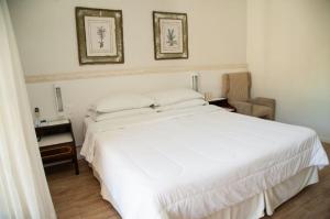 圣阿马鲁-达因佩拉特里斯卡尔达因佩拉特里斯广场Spa度假酒店的卧室配有一张白色床,墙上挂有两张照片