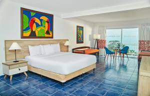 普拉亚布兰卡Royal Decameron Panama All Inclusive Plus的酒店客房设有一张大床和一张书桌。