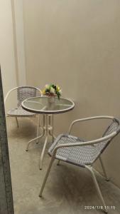 曼克拉La Casa de Joan的一张桌子、两把椅子和一张桌子,上面有鲜花