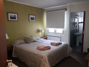 埃尔卡拉法特Los Lagos Hotel的一间卧室配有一张床,上面有两条毛巾